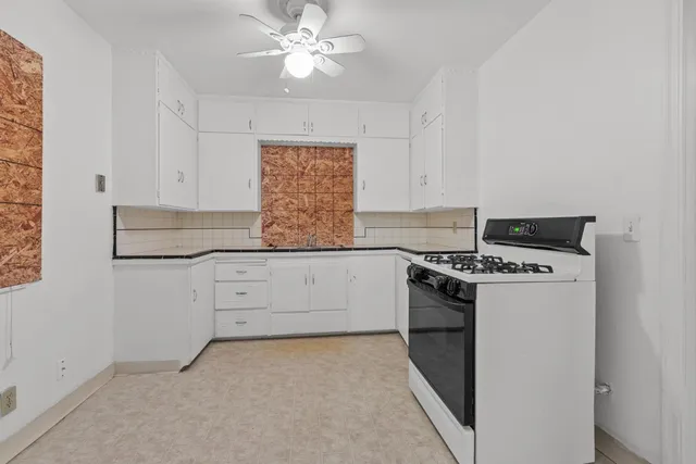 a kitchen with granite countertop white cabinets and white appliances