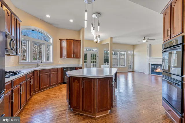 a large kitchen with stainless steel appliances wooden floors and wooden cabinets
