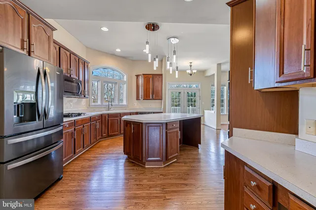 a kitchen with stainless steel appliances granite countertop wooden cabinets a oven and a sink