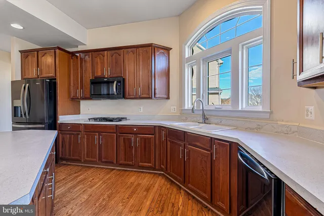 a open kitchen with a refrigerator and a stove top oven
