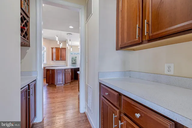 a view of an empty room with wooden floor and a fireplace