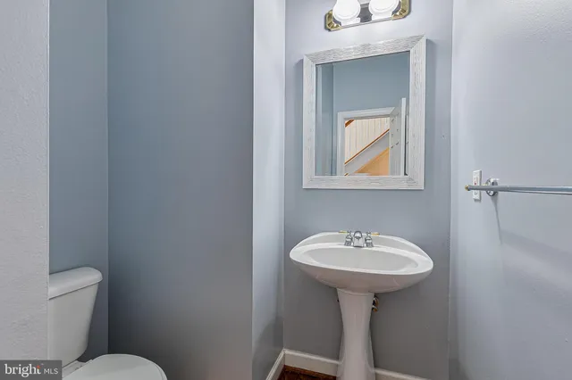 a view of staircase with lots of frames on wall and wooden floor