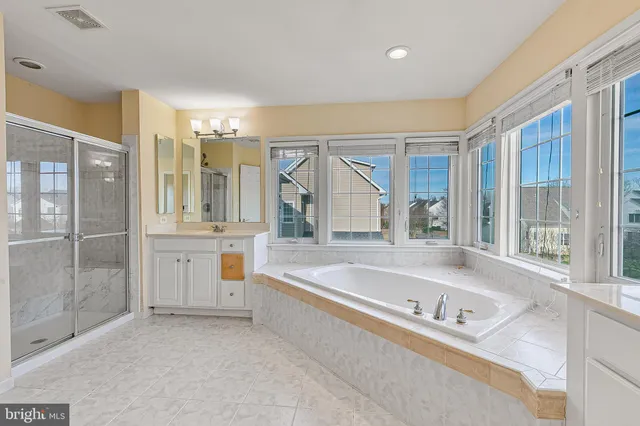 an empty room with ceiling fan and windows