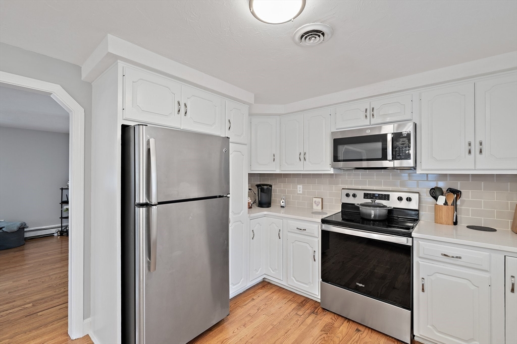 38 Roosevelt Street, Unit 2 Braintree, MA 02184 - Photo 6 of 17 a kitchen with a refrigerator stove and white cabinets