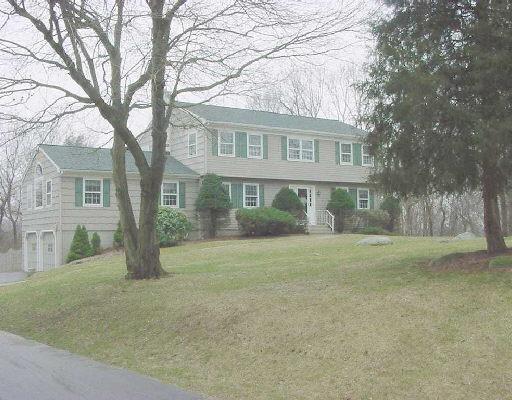 front view of a house with a yard and an trees
