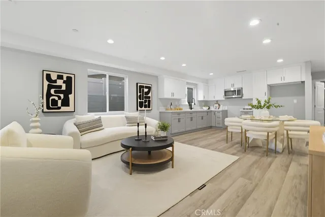 a living room with furniture and view of kitchen