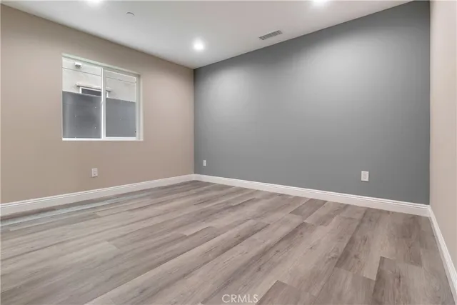 an empty room with wooden floor & closet area