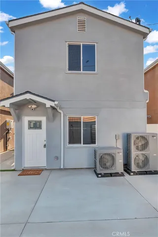a large kitchen with white cabinets and wooden floor