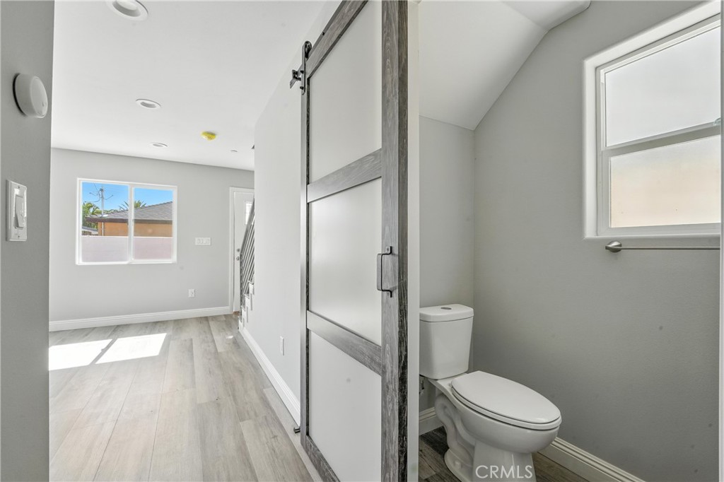 22022 Pioneer Boulevard Hawaiian Gardens, CA 90716 - Photo 42 of 50 a bathroom with a granite countertop toilet a sink a mirror and shower