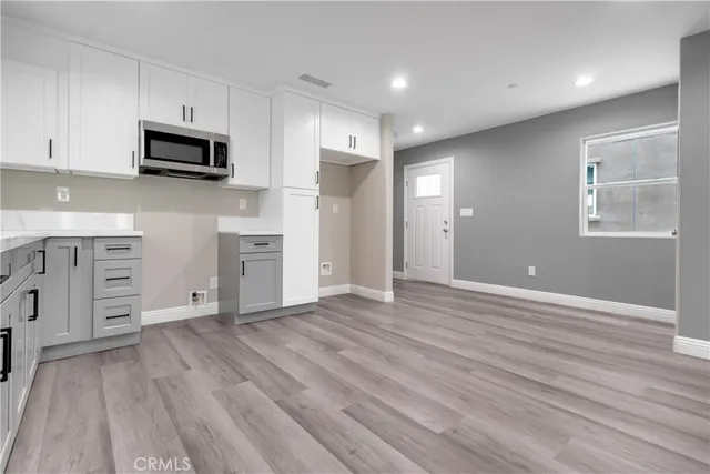 a view of a kitchen with wooden floor and electronic appliances