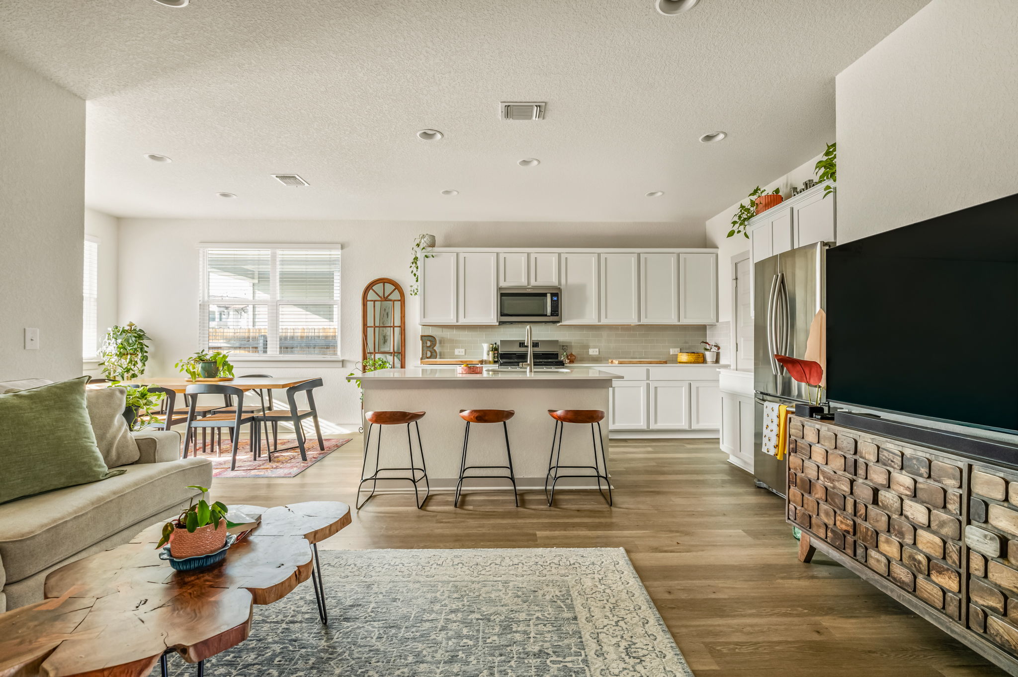 Living area with a textured ceiling, light wood-type flooring, and recessed lighting