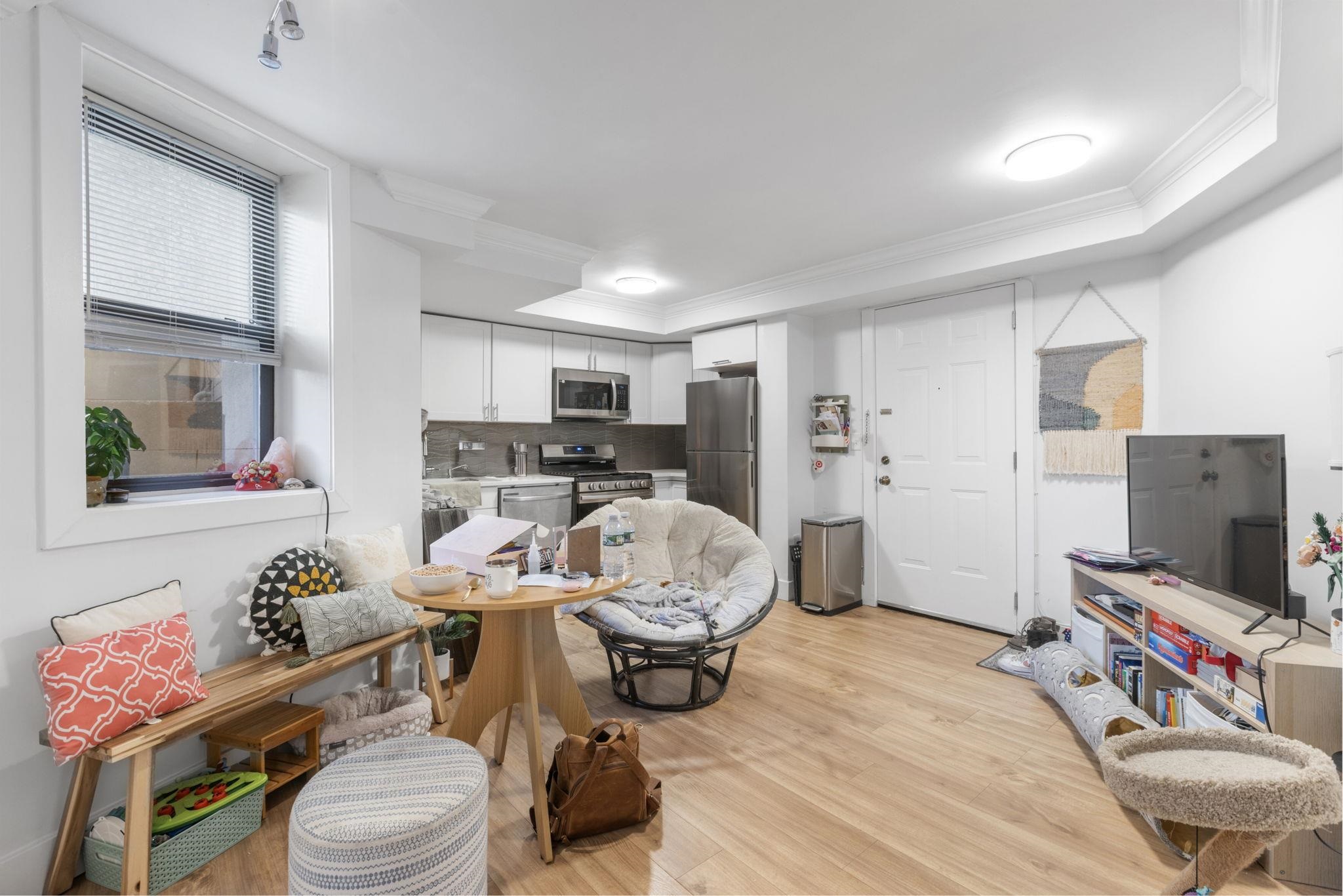 151 Sip Avenue, Unit 38 Jersey City, NJ 07306 - Photo 3 of 12 a room with furniture a flat screen tv and a window