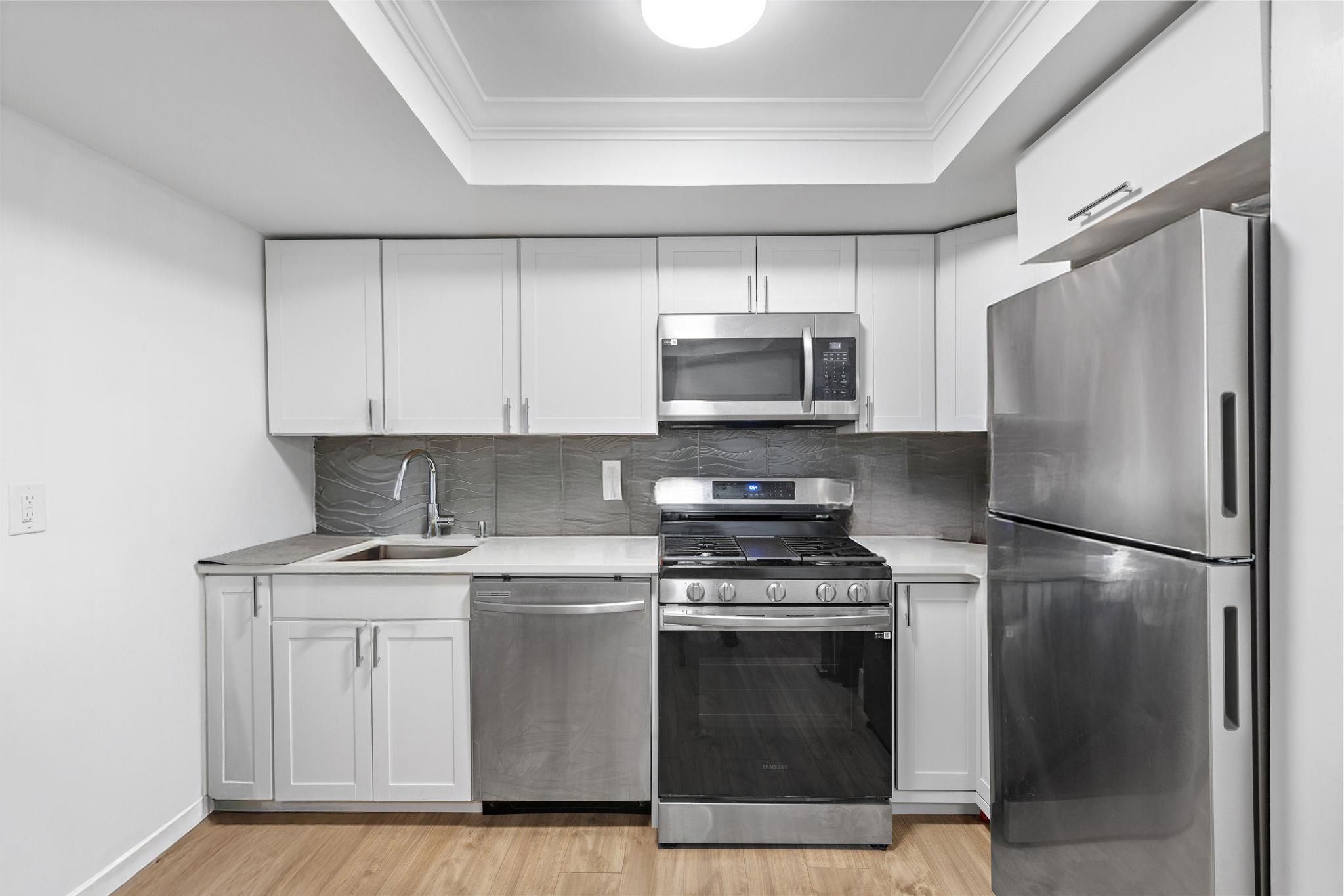 151 Sip Avenue, Unit 38 Jersey City, NJ 07306 - Photo 4 of 12 a kitchen with a sink stove and refrigerator