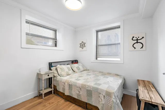 a bedroom with a bed and wooden floor