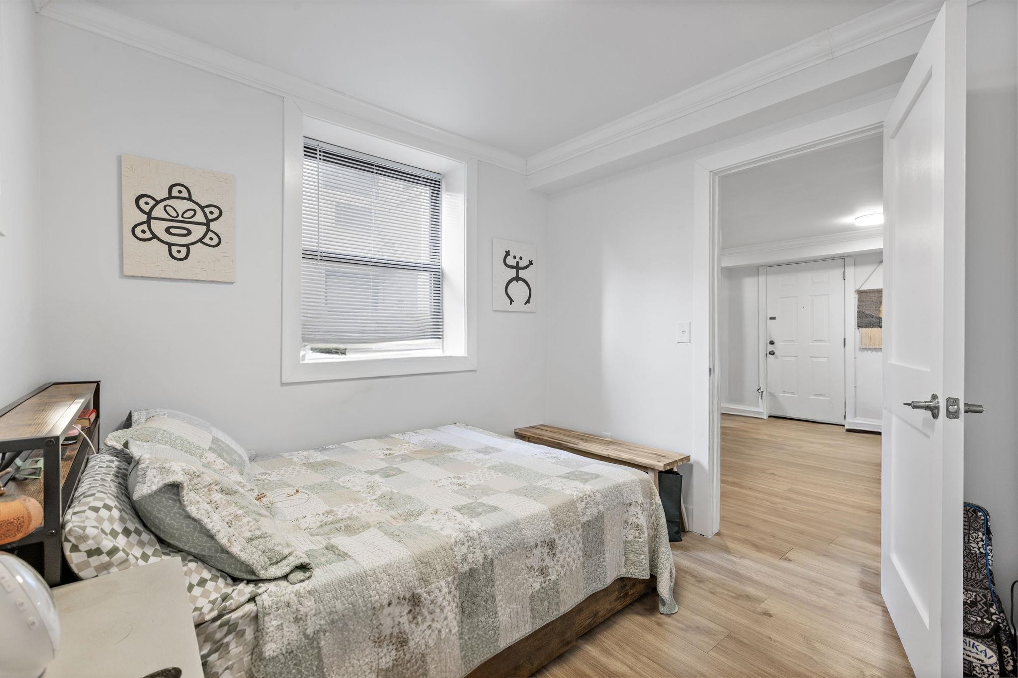 151 Sip Avenue, Unit 38 Jersey City, NJ 07306 - Photo 6 of 12 a bedroom with a bed and a window