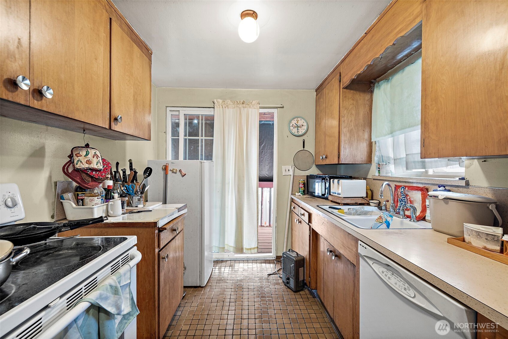 8829 20th Avenue Southwest Seattle, WA 98106 - Photo 19 of 40 a kitchen with a sink stove and cabinets