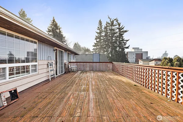 a view of balcony with wooden floor and fence and a large window