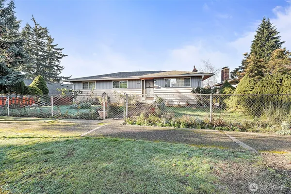 a front view of a house with a yard and potted plants