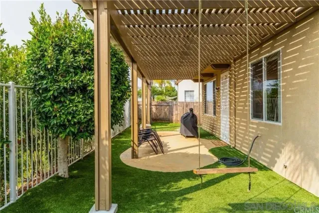a view of a house with backyard and sitting area
