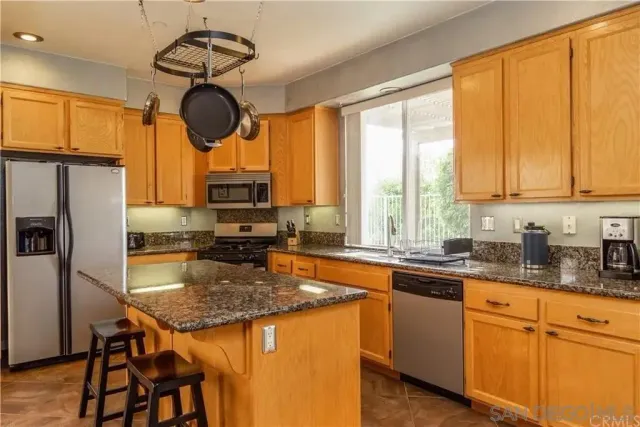a kitchen with a counter space appliances cabinets and furniture