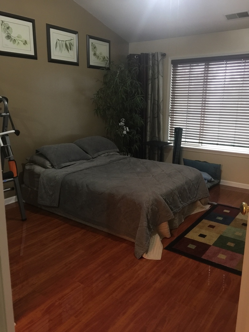 3493 Ravinia Circle, Unit 3493 Aurora, IL 60504 - Photo 11 of 18 a bedroom with a bed and wooden floor