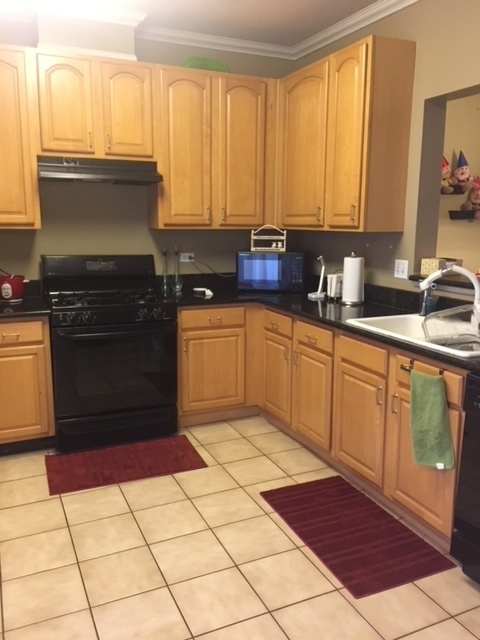 3493 Ravinia Circle, Unit 3493 Aurora, IL 60504 - Photo 6 of 18 a kitchen with stainless steel appliances granite countertop a stove a sink and a microwave