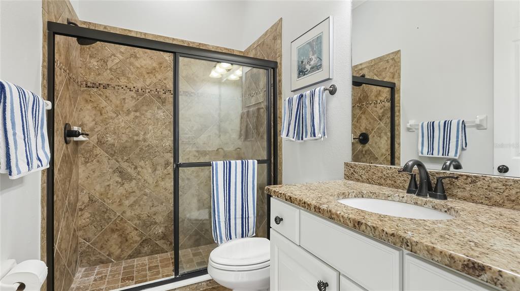 5621 Rock Dove Drive Sarasota, FL 34241 - Photo 27 of 49 a bathroom with a granite countertop sink toilet and shower