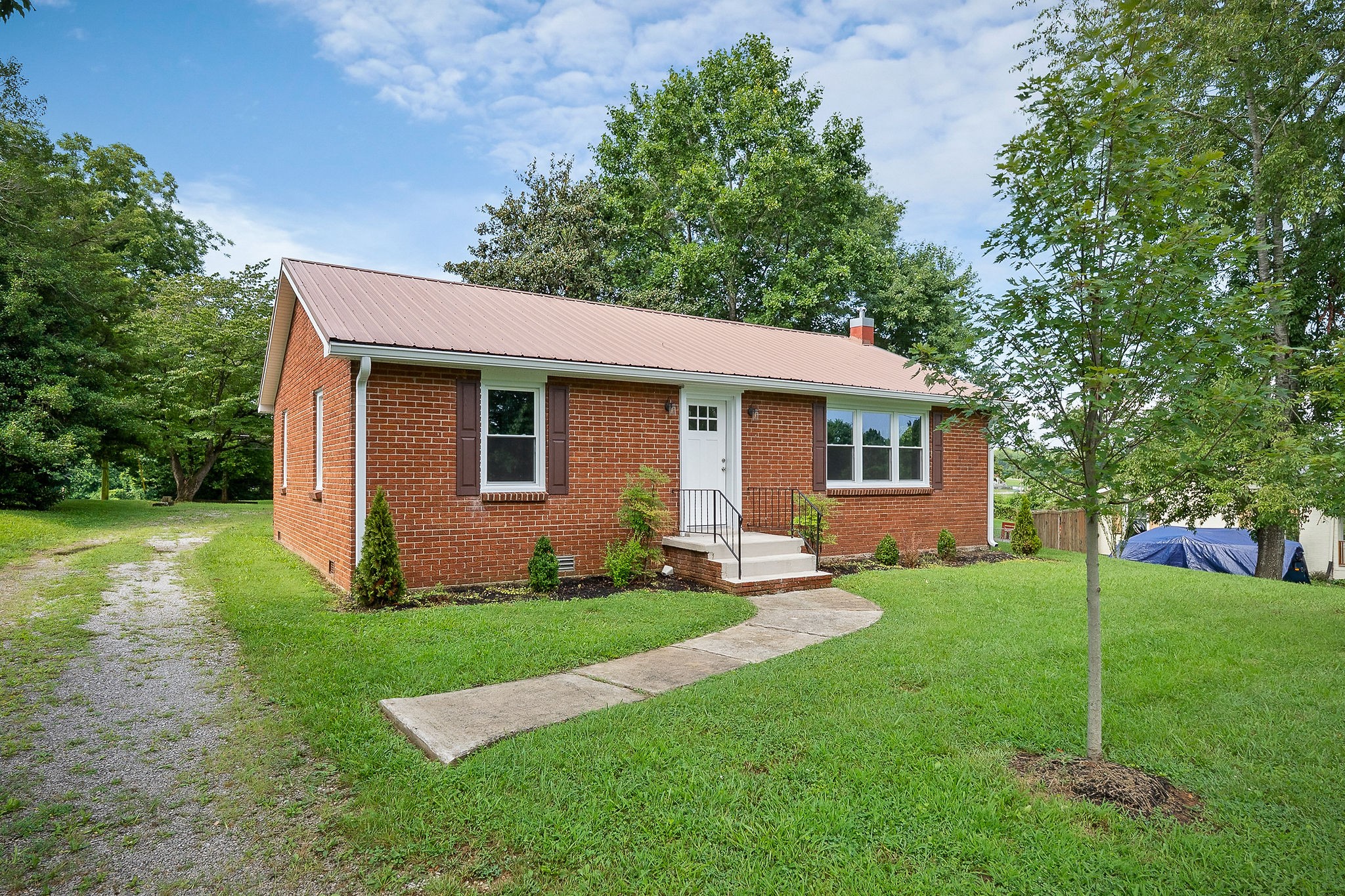 218 Roosevelt Road McMinnville, TN 37110 - Photo 1 of 31 a backyard of a house with potted plants and large tree