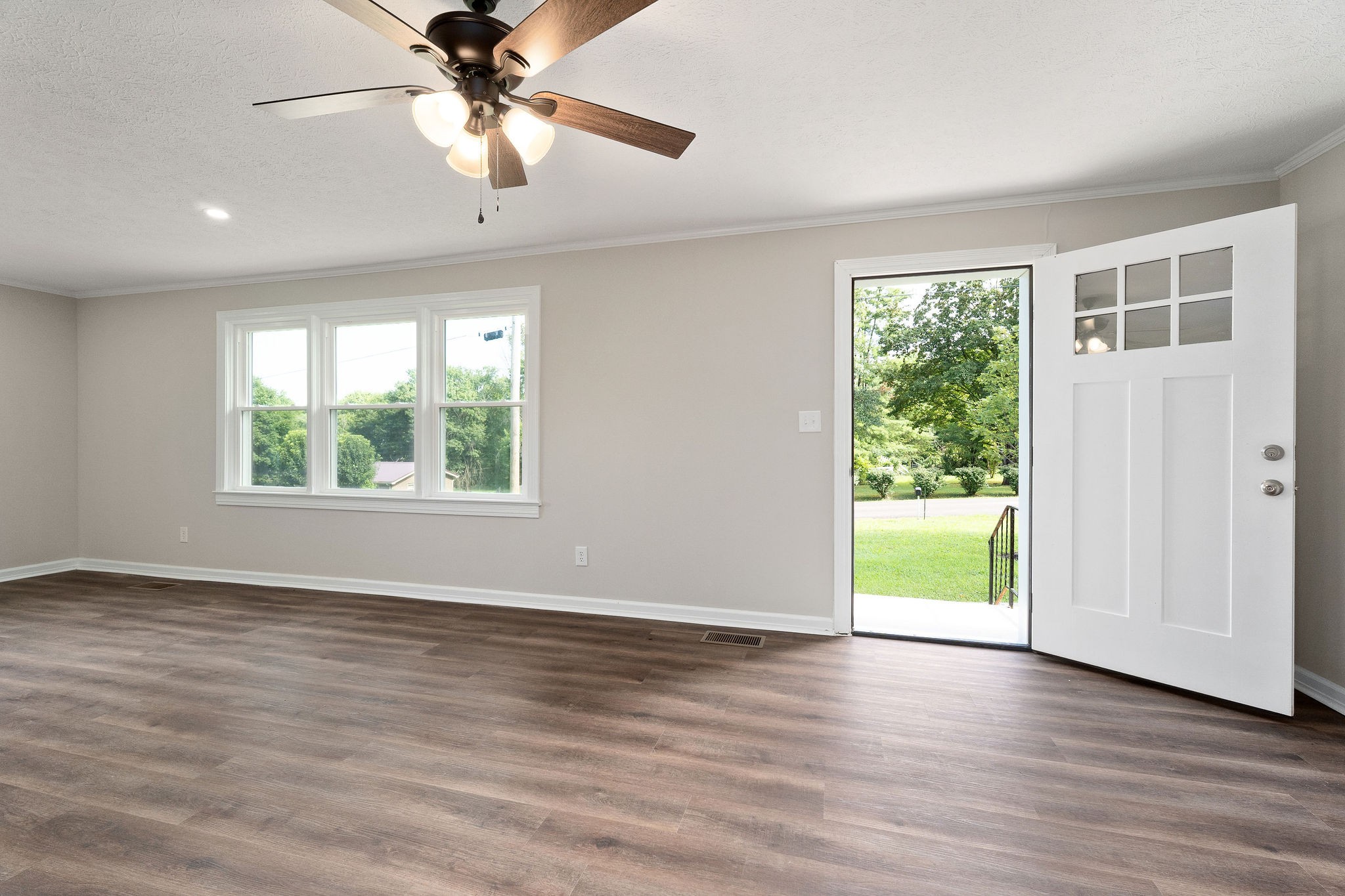 218 Roosevelt Road McMinnville, TN 37110 - Photo 11 of 31 an empty room with wooden floor chandelier fan and windows