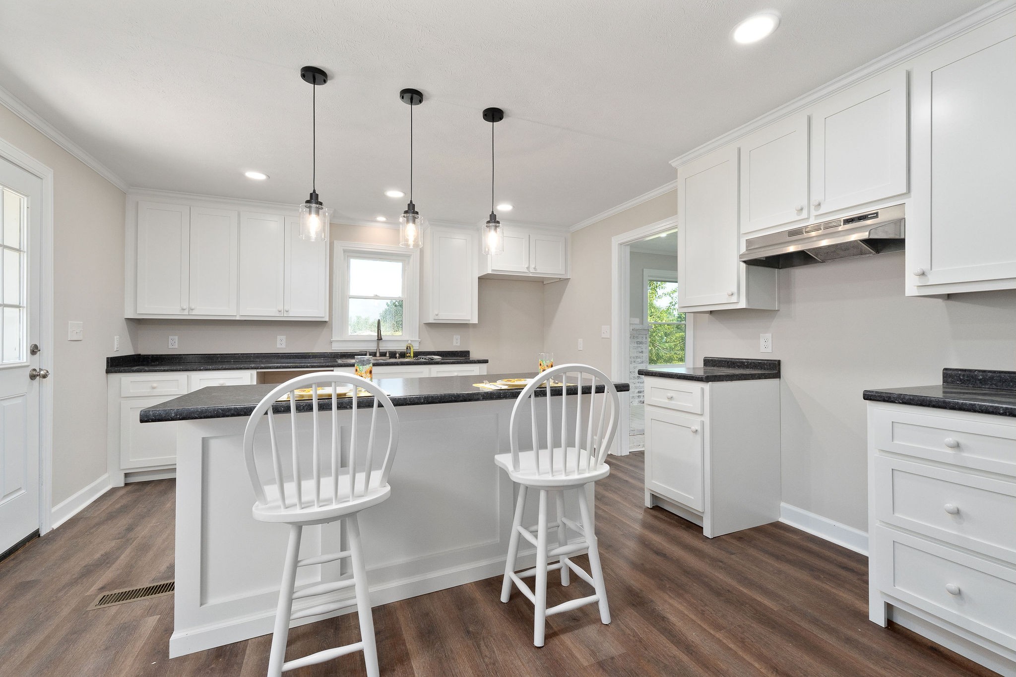 218 Roosevelt Road McMinnville, TN 37110 - Photo 19 of 31 a kitchen with stainless steel appliances granite countertop a stove a refrigerator a kitchen island a wooden floor and white cabinets