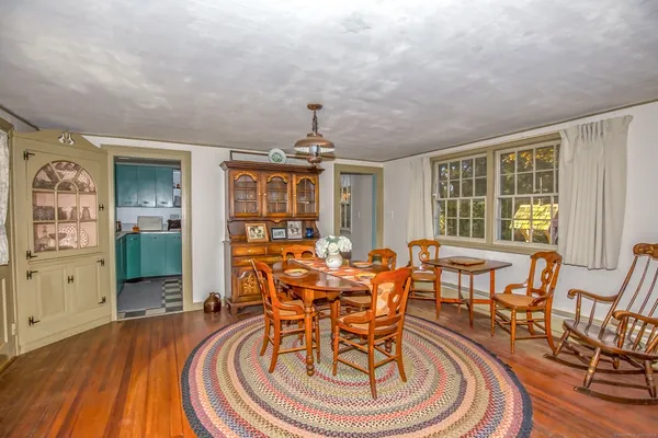 a dining room with furniture a chandelier and wooden floor