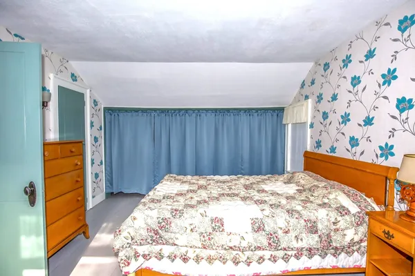 a bed room with a bed and a painting on the wall