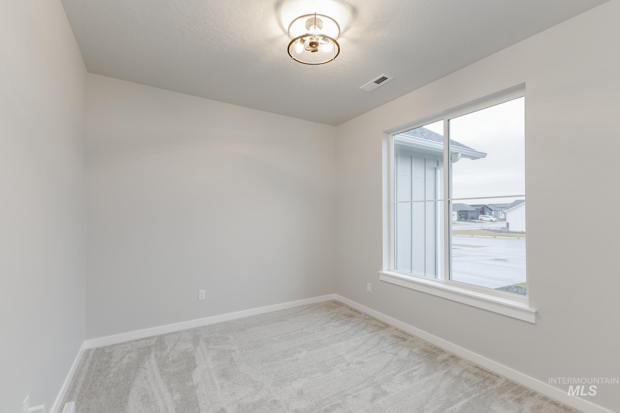 6558 South Sunfish Avenue Boise, ID 83709 - Photo 10 of 32 Unfurnished room featuring baseboards and light colored carpet
