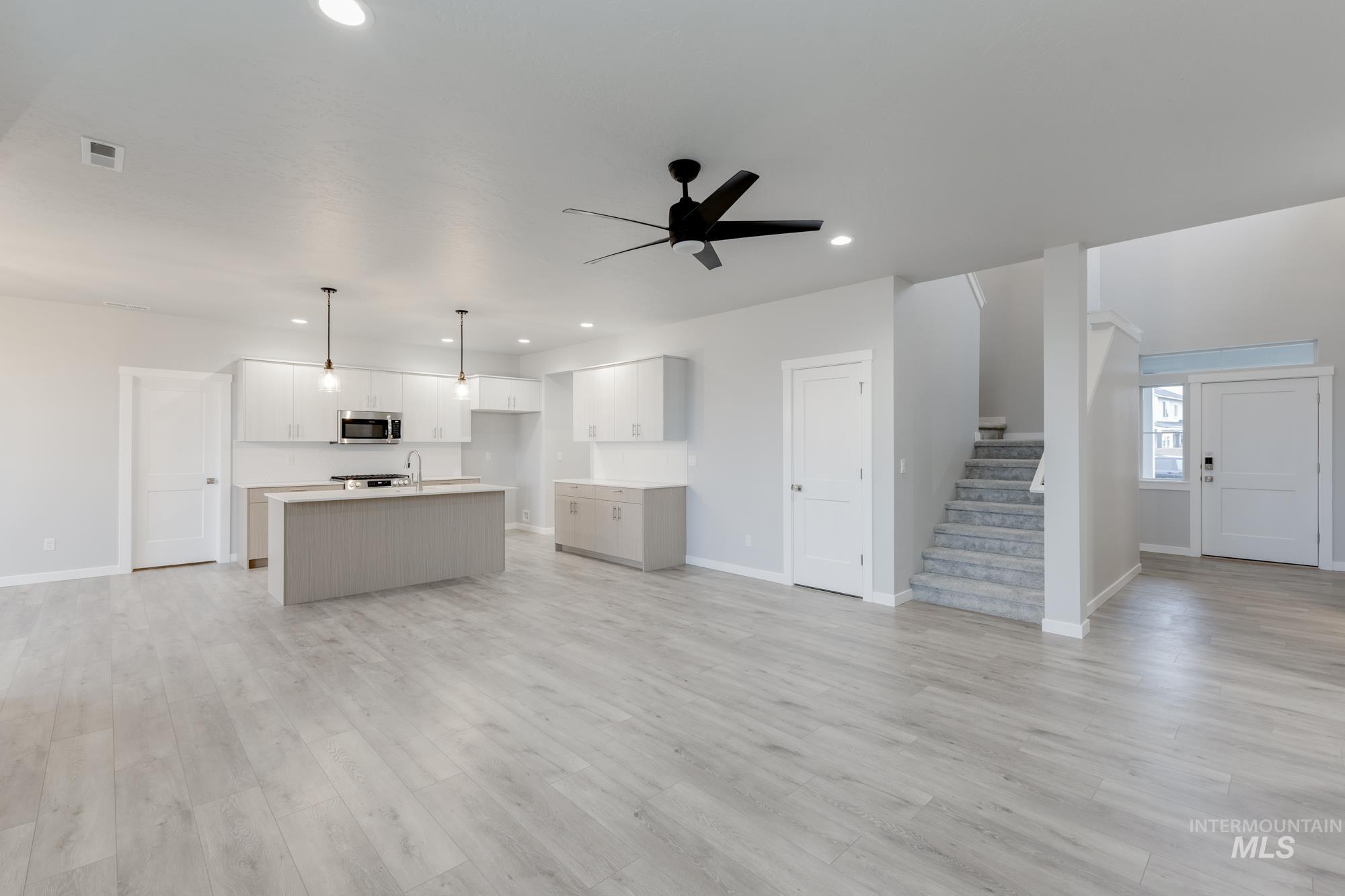 6558 South Sunfish Avenue Boise, ID 83709 - Photo 32 of 32 Kitchen featuring open floor plan, an island with sink, decorative light fixtures, light countertops, and a ceiling fan