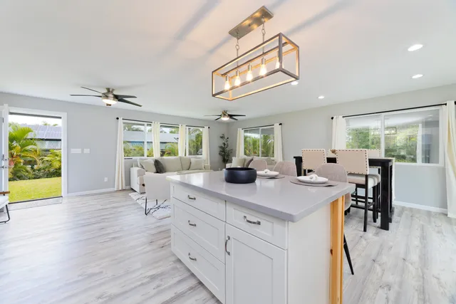a view of a dining room with furniture a kitchen and chandelier