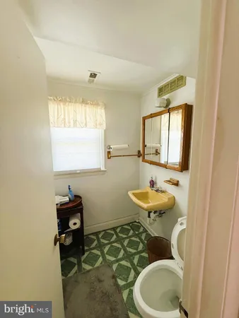 a bathroom with a sink mirror and toilet