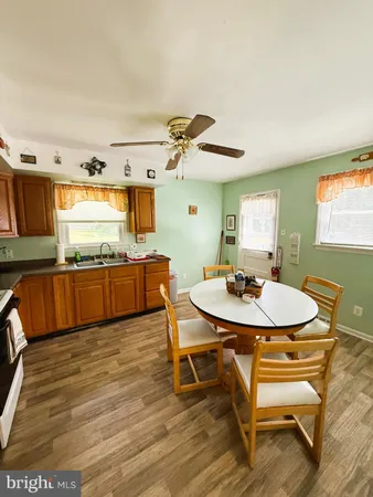 a view of a kitchen with kitchen island a sink and a wooden floor