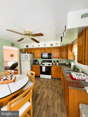 a kitchen with stainless steel appliances wooden floor dining table and chairs