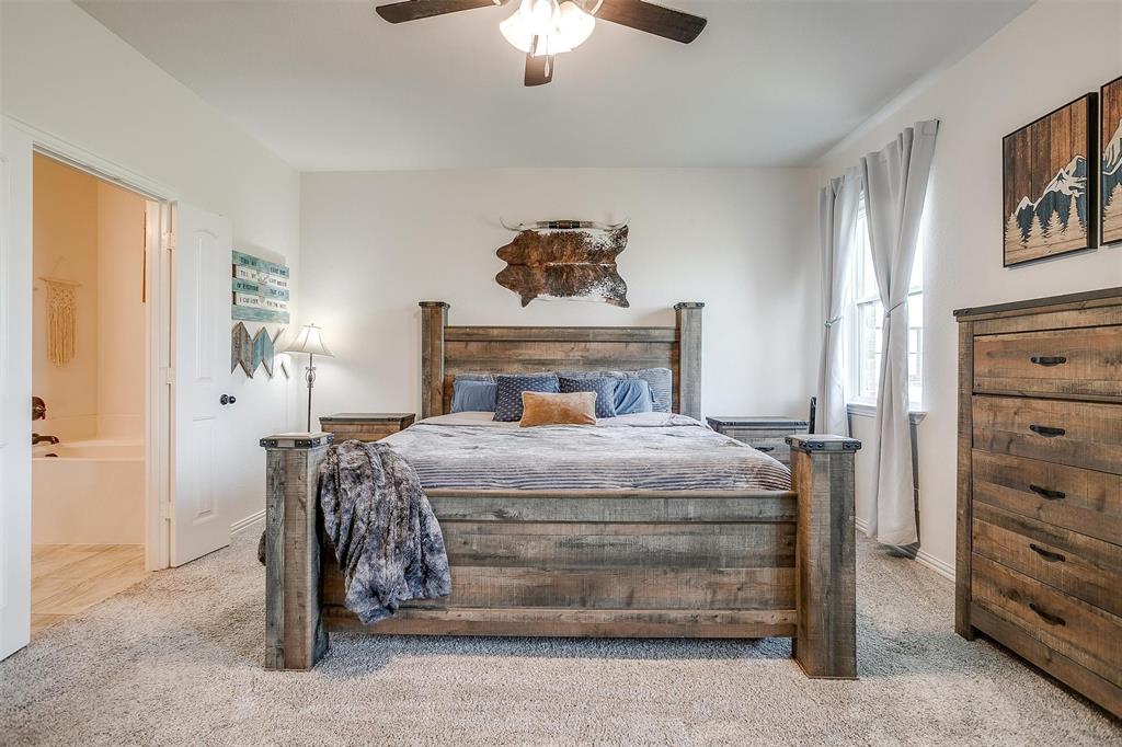 340 Sanger Drive Springtown, TX 76082 - Photo 19 of 38 a bedroom with a bed and a chandelier