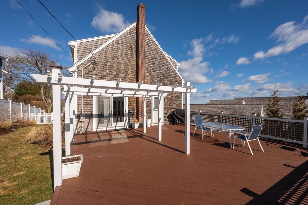 6 Governor Long Road Hingham, MA 02043 - Photo 21 of 24 a view of a patio with a table and chairs under an umbrella
