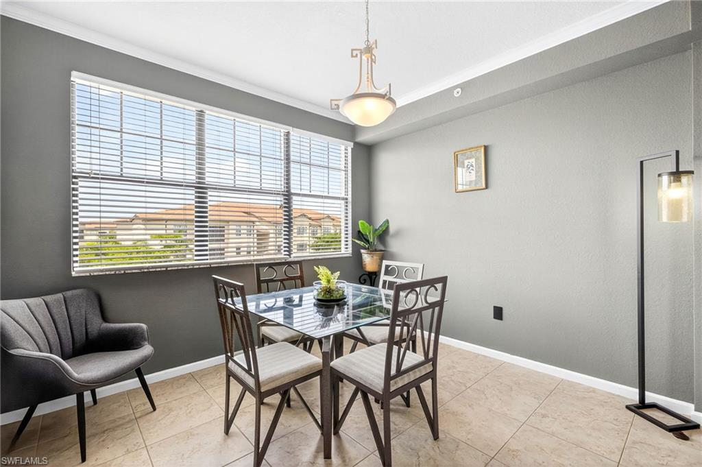 12955 Positano Circle, Unit 305 Naples, FL 34105 - Photo 5 of 10 Dining space featuring crown molding and baseboards