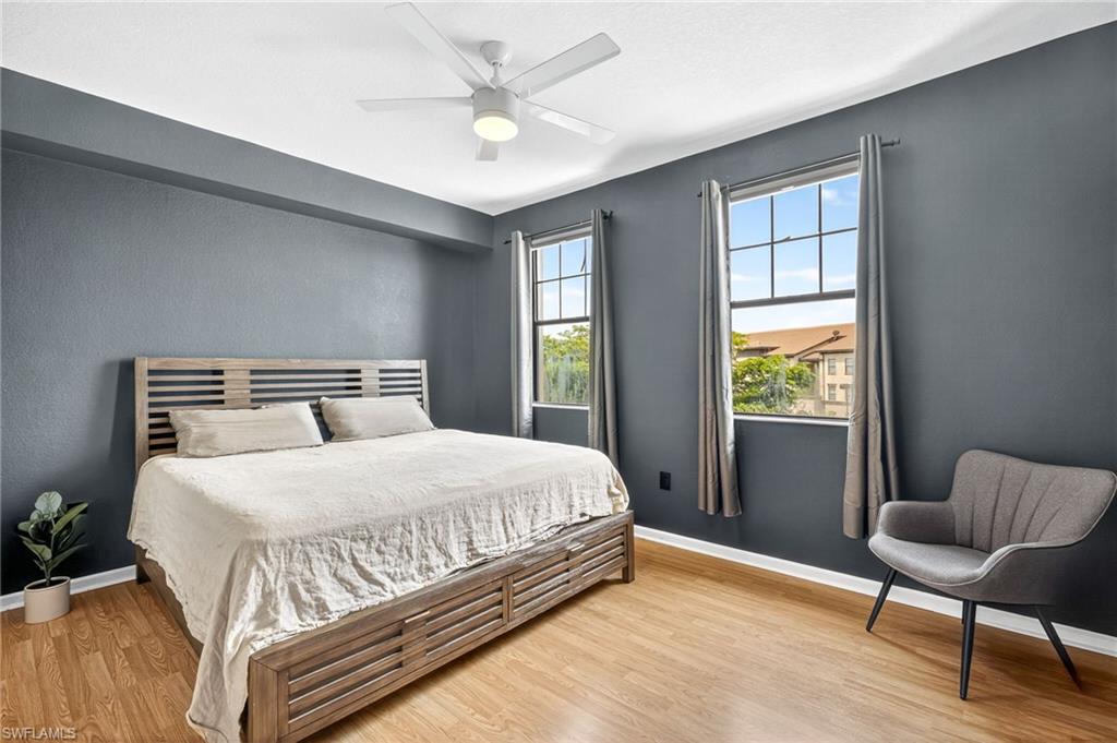 12955 Positano Circle, Unit 305 Naples, FL 34105 - Photo 6 of 10 Bedroom with light wood finished floors and ceiling fan