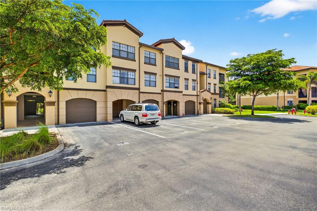 12955 Positano Circle, Unit 305 Naples, FL 34105 - Photo 9 of 10 View of apartment building / complex featuring an attached garage