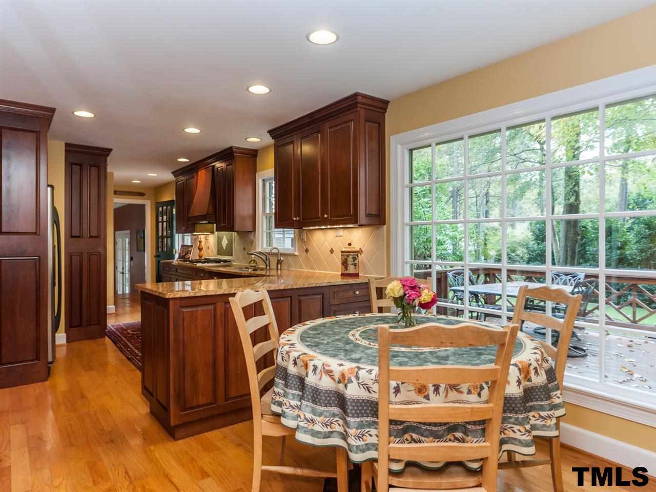 1804 Pony Run Road Raleigh, NC 27615 - Photo 9 of 25 a kitchen with kitchen island granite countertop wooden floors and a view of living room