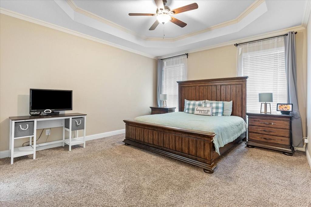 502 Ritchey Street Gainesville, TX 76240 - Photo 19 of 29 a bedroom with a bed and a flat screen tv