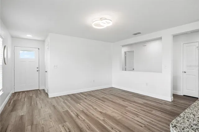 a view of a room with wooden floor and white walls