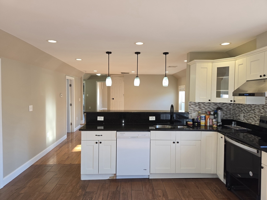 3 Pearl Street, Unit 2 Stoneham, MA 02180 - Photo 14 of 21 a large white kitchen with a sink and dishwasher a stove with wooden floor