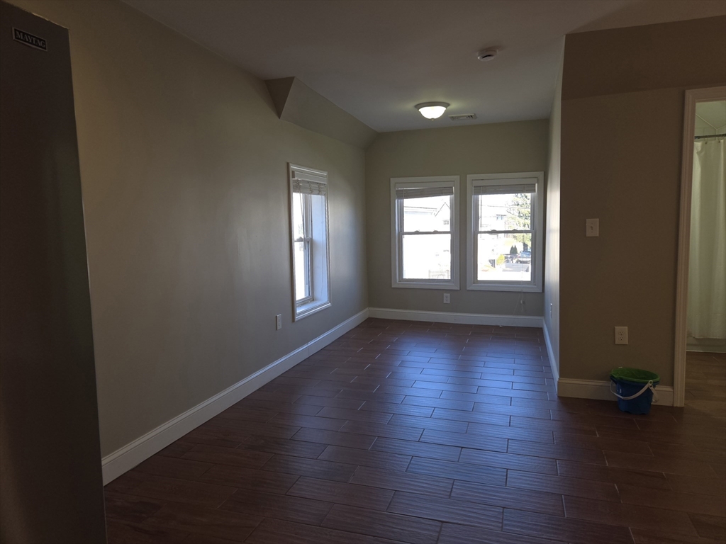 3 Pearl Street, Unit 2 Stoneham, MA 02180 - Photo 15 of 21 an empty room with wooden floor and windows
