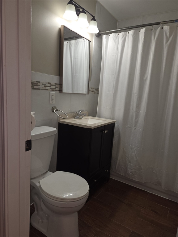 3 Pearl Street, Unit 2 Stoneham, MA 02180 - Photo 16 of 21 a bathroom with a sink a toilet and a mirror