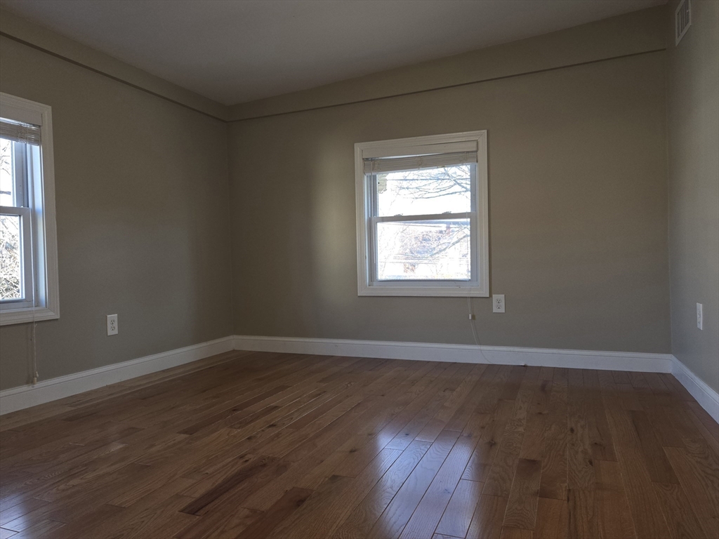 3 Pearl Street, Unit 2 Stoneham, MA 02180 - Photo 19 of 21 a view of an empty room with wooden floor and a window